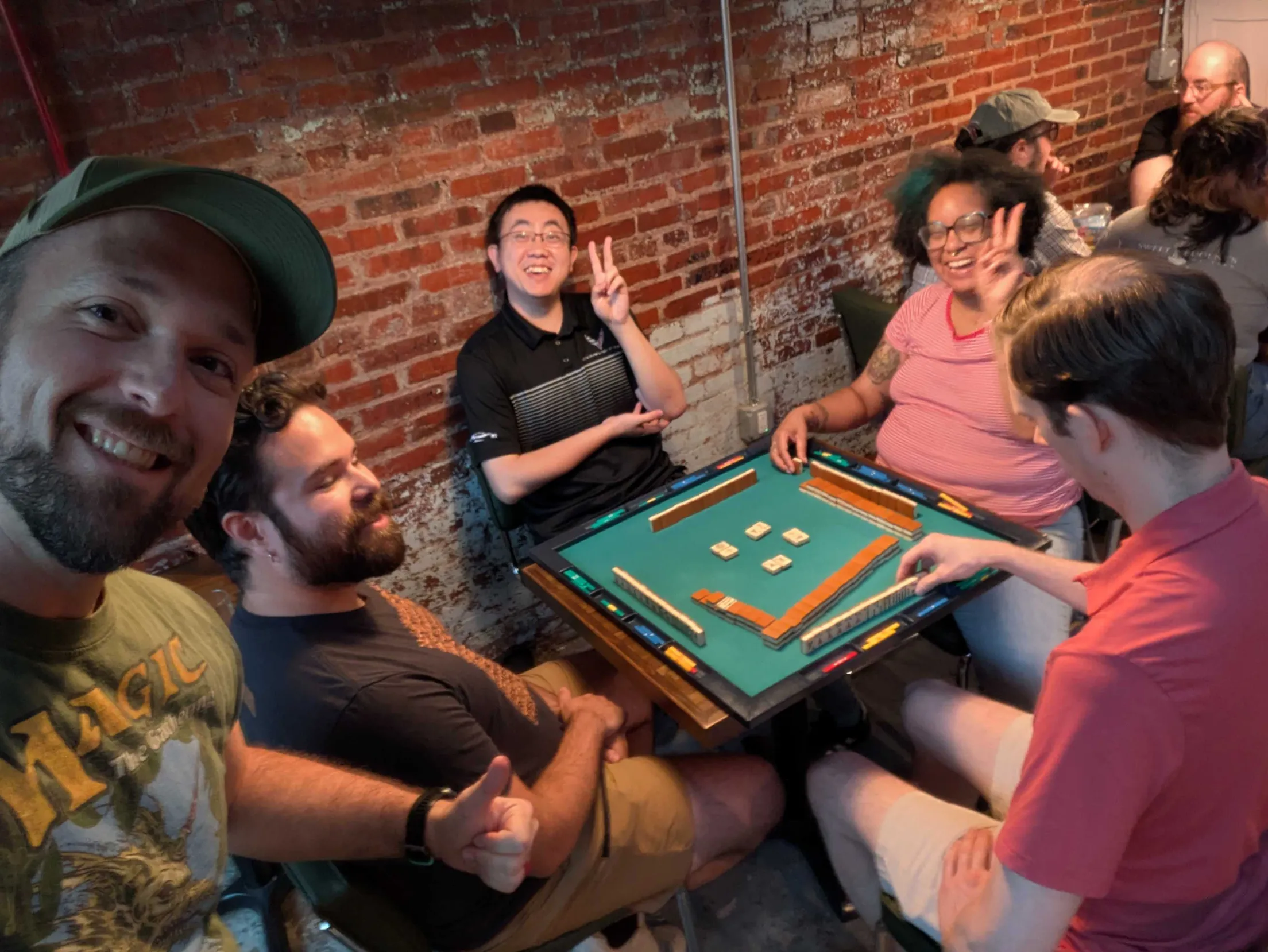 Friends taking a selfie mid-game at a Charm City Riichi riichi mahjong meetup