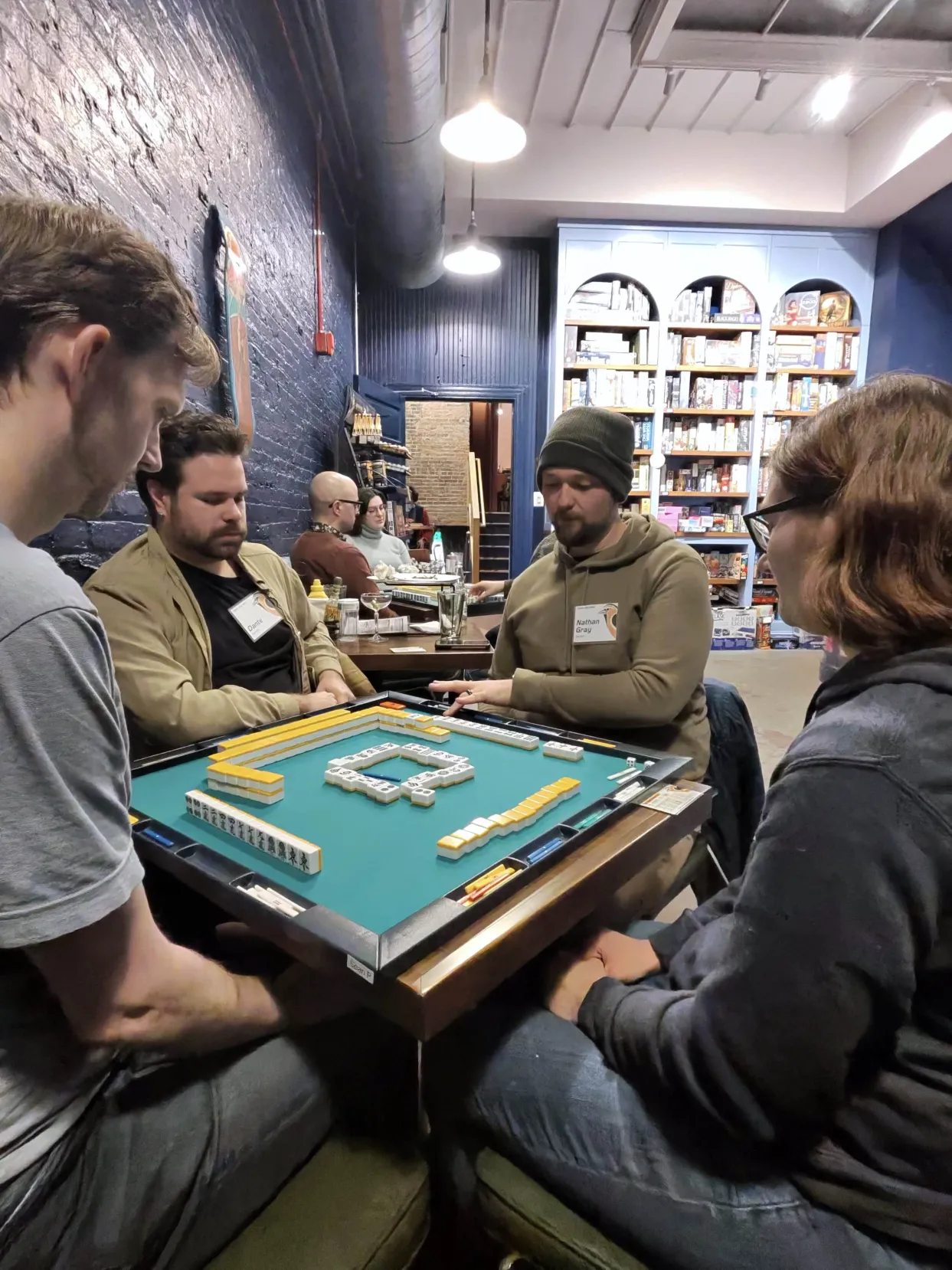 Focused riichi mahjong gameplay at No Land Beyond in Baltimore, MD
