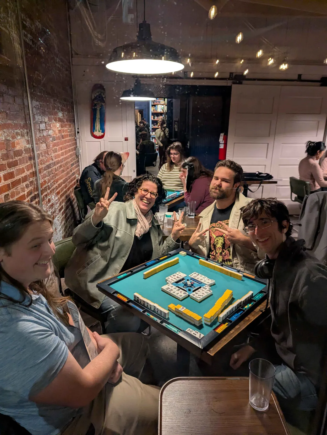 Charm City Riichi players smiling and celebrating at a weekly mahjong night in Baltimore